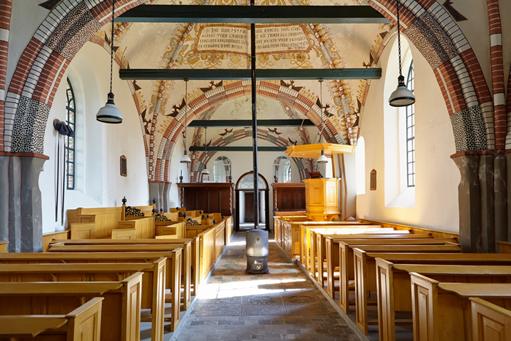 Interieur van de kerk met gewelfschilderingen.